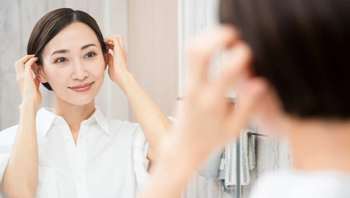 白髪染め後の髪にふれる女性